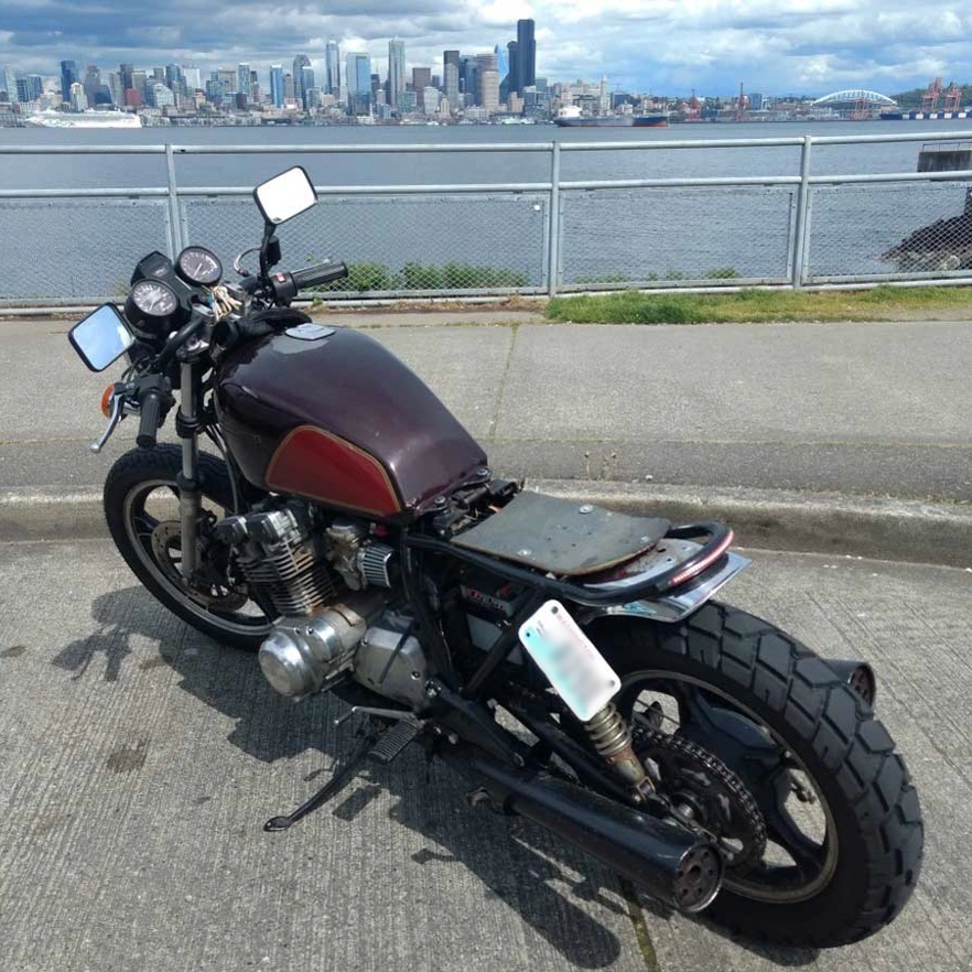 Unfortunately I don't have any pictures of the bike prior to chopping the back off and welding on the tail hoop. Afterwards I didn't have a seat so I bolted on this skateboard.