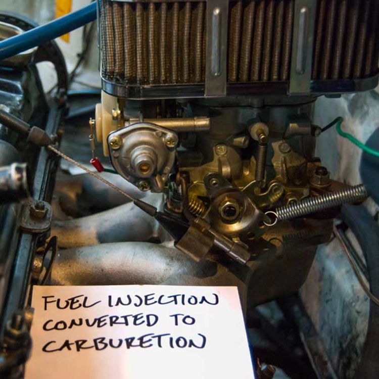 The replacement gas engine was fuel injected.  Carburation simplified the install by removing the necessity of wiring a more complex fuel injection system.